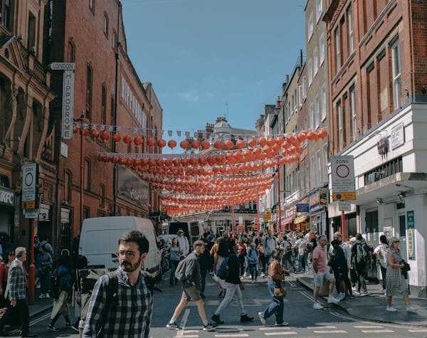 Bustling London street scene adorned with festive red lanterns and a lively crowd.