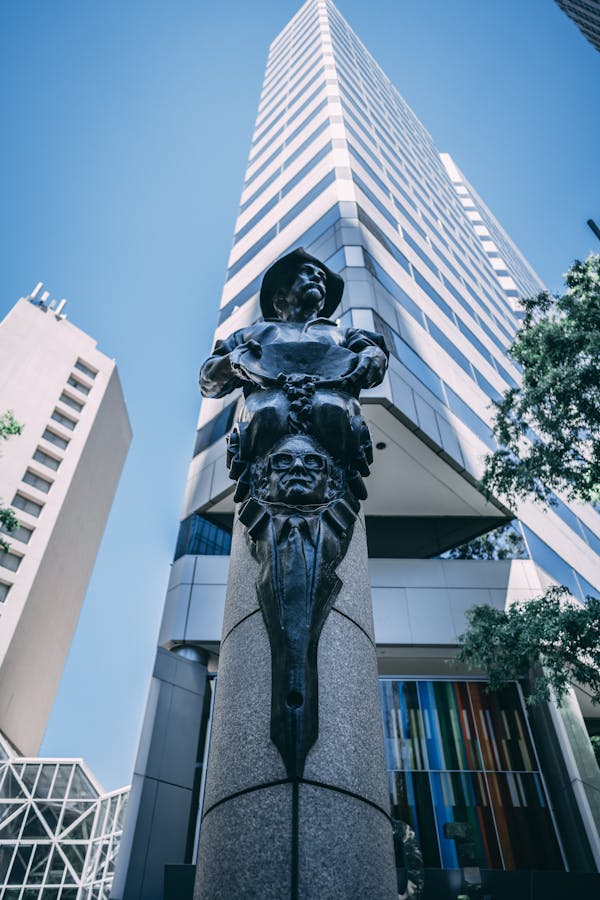 From below of old metal sculpture placed on square near high modern building in Uptown Charlotte