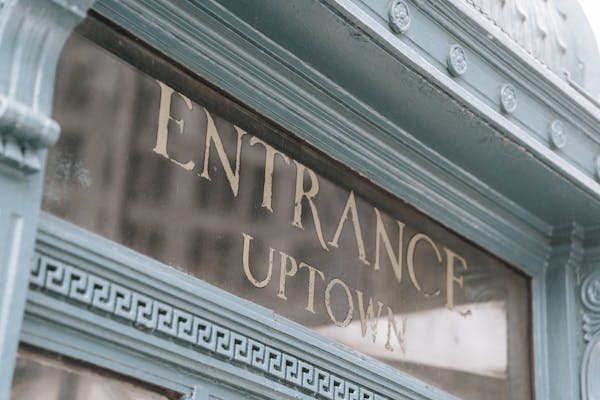 Glass signboard with inscription placed in aged fashioned light blue facade of pub on street in daylight