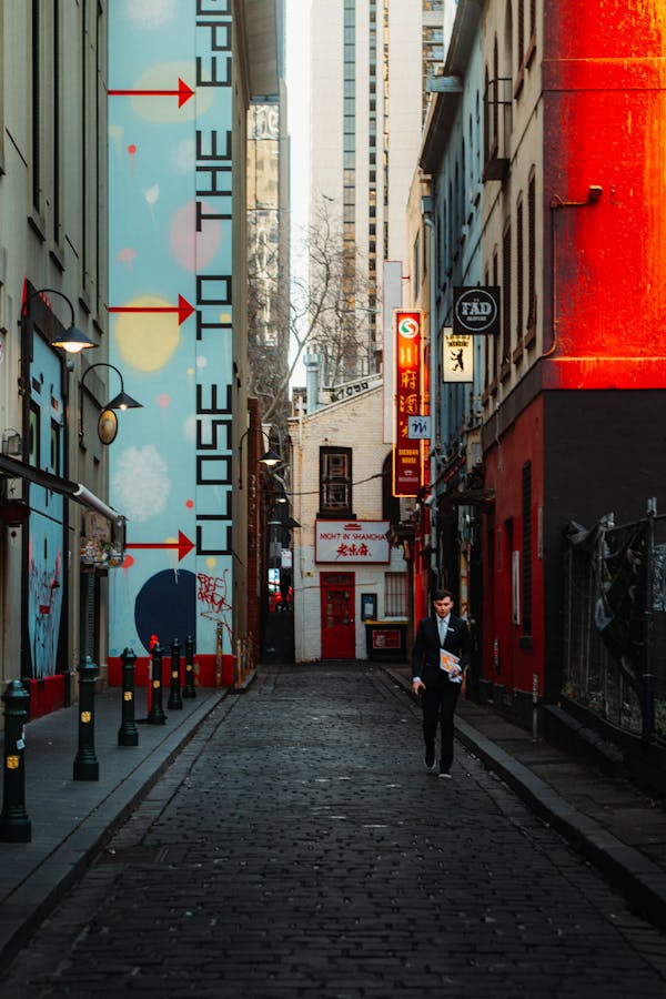 Vibrant alley in Melbourne's Chinatown featuring street art and bright signage.